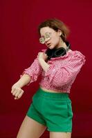 portrait of a girl in green shorts glasses with diamond headphones posing photo