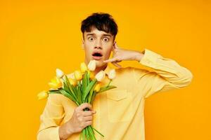 handsome guy in yellow glasses with a bouquet of flowers isolated background unaltered photo