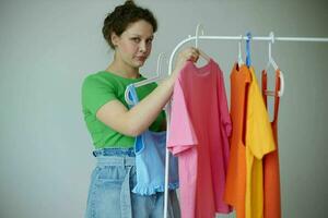 pretty girl trying on clothes wardrobe Youth style light background unaltered photo