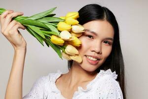 woman with Asian appearance flowers spring posing light background unaltered photo