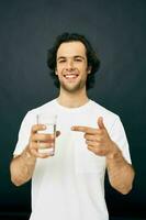 alegre hombre vaso de agua en su manos emociones posando beige antecedentes foto