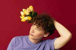 adolescente participación un amarillo ramo de flores de flores púrpura camisetas aislado antecedentes inalterado foto