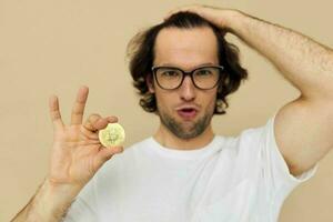 hermoso hombre en un blanco camiseta con bitcoin criptomoneda aislado antecedentes foto