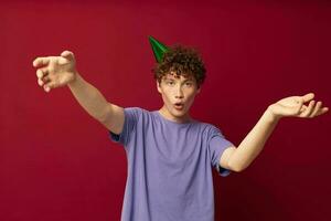 with a cap on his head kinky guy fashion posing hand gestures red background unaltered photo