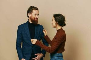 Man and woman couple in a relationship smile and interaction on a beige background in a real relationship between people photo