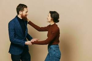 Man and woman couple in a relationship smile and interaction on a beige background in a real relationship between people photo