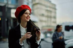 Woman smile with teeth tourist walks walks in the city on the background of office buildings, stylish fashionable clothes and make-up, spring walk, travel. photo