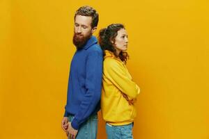 Man and woman couple smiling cheerfully and crooked with glasses, on yellow background, symbols signs and hand gestures, family shoot, newlyweds. photo