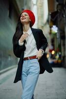 Fashion woman smile with teeth portrait walking tourist in stylish clothes in jacket with red lips walking down narrow city street flying hair, travel, cinematic color, retro vintage style. photo