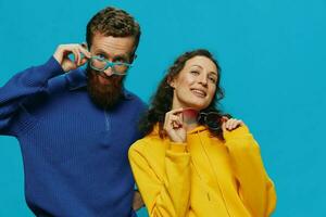 A woman and a man fun couple cranking and showing signs with their hands smiling cheerfully, on a blue background, The concept of a real relationship in a family. photo