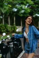 Portrait of woman brunette smile with teeth running down the street against backdrop palm trees in the tropics, summer vacations and outdoor recreation, the carefree lifestyle of a freelance student. photo