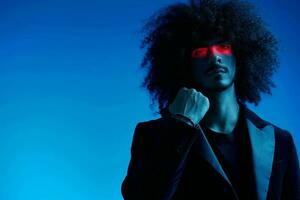 Fashion portrait of a man with curly hair on a blue background with a red stripe of light, multicolored light, trendy, modern concept. photo