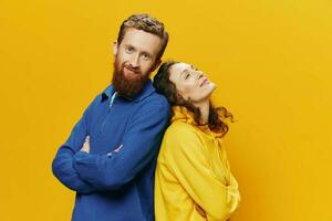 hombre y mujer Pareja sonriente alegremente y torcido con anteojos, en amarillo fondo, símbolos señales y mano gestos, familia disparar, recién casados. foto