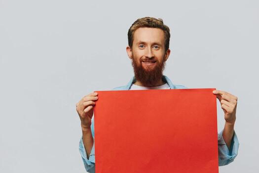 Portrait of an adult male on a gray background with a red piece of paper for your design and text, layout, copy space, space for text photo
