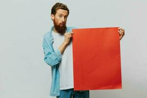 retrato de un adulto masculino en un gris antecedentes con un rojo pedazo de papel para tu diseño y texto, disposición, Copiar espacio, espacio para texto foto