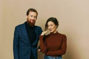 Man and woman couple in a relationship smile and interaction on a beige background in a real relationship between people photo