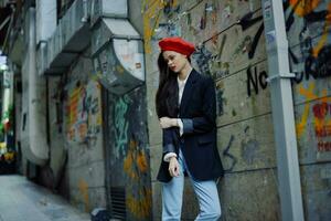 Fashion woman portrait walking tourist in stylish clothes with red lips walking down a narrow city street, travel, cinematic color, retro vintage style, dramatic against a wall with graffiti. photo