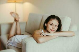 Happy girl smile lying on the couch at home, relaxing at home, comfort, sunshine. photo