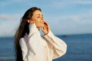 Woman beauty smile with teeth freedom on vacation walks along the beach near the ocean in Bali sunset, happy travel and vacation, sunset light, flying hair, enjoyment of relaxation and harmony photo