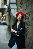 Fashion woman portrait walking tourist in stylish clothes with red lips walking down a narrow city street, travel, cinematic color, retro vintage style, dramatic against a wall with graffiti. photo