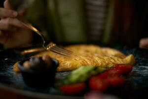 Woman in cafe eating breakfast omelet with vegetables close-up of fork with food, home-cooked food in restaurant, social media content photo