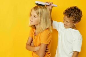 a boy combing a girl's blonde hair photo