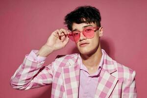 foto de romántico joven novio en rosado lentes rosado chaqueta de sport posando estudio rosado antecedentes inalterado