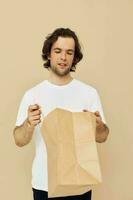 handsome man in a white T-shirt with paper bag Lifestyle unaltered photo