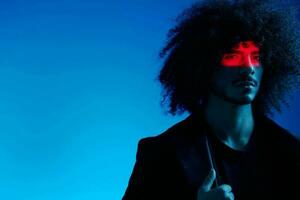 Fashion portrait of a man with curly hair on a blue background, multinational, colored light, trendy, modern concept. photo