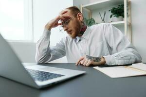 A man in a wheelchair a businessman in the office works, severe fatigue and emotional burnout, integration into society, the concept of work a person with disabilities photo