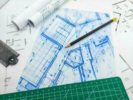 Pencils, ruler, green matte and paper engineering house drawings and blueprints. photo
