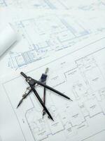 Paper home floor plan with compass. Architectural sketching process concept. Floor plan on architect's desk. photo