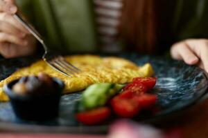 Woman in cafe eating breakfast omelet with vegetables close-up of fork with food, home-cooked food in restaurant, social media content photo