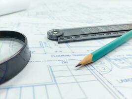 Image of blueprints with level pencil, ruler and magnifier on table photo