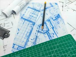 Pencils, ruler, green matte and paper engineering house drawings and blueprints. photo