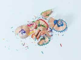 Shavings from multicolored pencils on white background photo