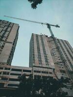 construcción de edificios sin terminar y grúas de construcción contra un fondo de cielo azul claro foto