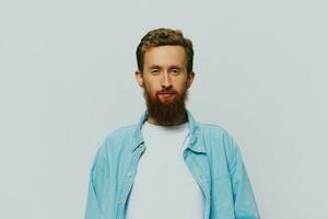 Male hipster portrait smile on gray background in blue shirt and white t-shirt, portrait of a man with a beard photo