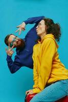 Woman and man smile sitting on suitcase with red suitcase smile, on blue background, packing for trip, family vacation trip. photo