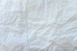 Wrinkled or crumpled white stencil paper or tissue after use in toilet or restroom with large copy space used for background texture in decorative art work. photo