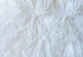 Wrinkled or crumpled white stencil paper or tissue after use in toilet or restroom with large copy space used for background texture in decorative art work photo