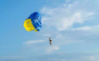 Tourist enjoying a parasailing ride at Patong beach in Phuket of Thailand. Water sport activity photo