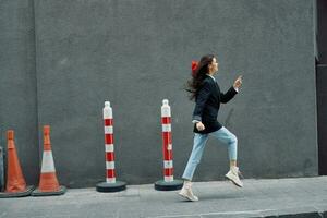 Fashion woman running down the street in front of the city tourist in stylish clothes with red lips and red beret, travel, cinematic color, retro vintage style. photo