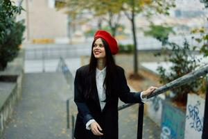 Fashion woman walking down steps against city backdrop in stylish clothes with red lips and red beret, travel, cinematic color, retro vintage style, urban fashion lifestyle. photo