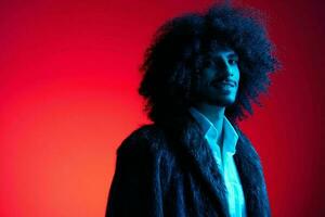 Fashion portrait of a man with curly hair on a red background, multinational, colored light, trendy, modern concept. photo