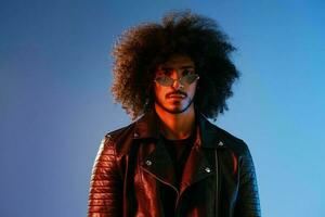 Portrait of a stylish man with curly hair on a blue background multinational, colored light, trendy glasses, modern concept. photo