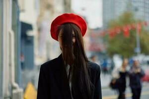 un hermosa sonrisa mujer con dientes camina en el ciudad en contra el fondo de oficina edificios, elegante de moda Clásico ropa y constituir, otoño caminar, viajar. foto