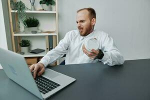 A man in a wheelchair, a businessman with tattoos in the office at a laptop, a coffee break, annoyance, the concept of working a person with disabilities, freedom from social frames photo