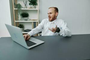 A man in a wheelchair, a businessman with tattoos in the office at a laptop, a coffee break, annoyance, the concept of working a person with disabilities, freedom from social frames photo