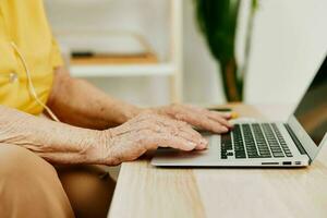 Cookie elderly woman typing on a modern laptop text close-up hands with a keyboard, online chatting. photo